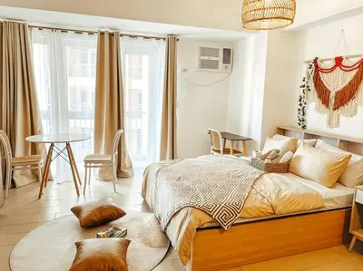 a bedroom with a bed and a table with chairs at Venice Luxury Residences Studio McKinley Hill in Manila