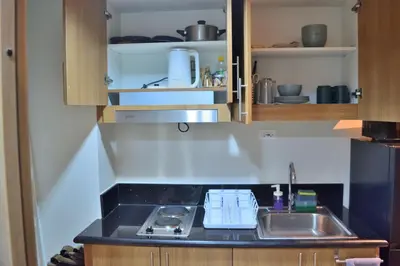 a kitchen with a sink and a counter top at Callie's Cozy Home at Shore 3 Mall of Asia in Manila