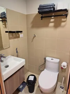 a bathroom with a white toilet and a sink at Callie's Cozy Home at Shore 3 Mall of Asia in Manila