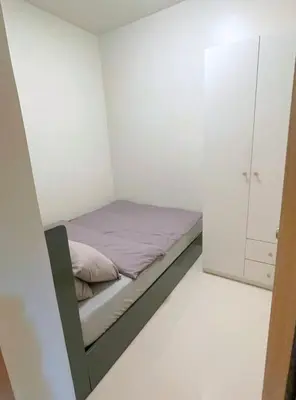 a small bedroom with a bed and a cabinet at Callie's Cozy Home at Shore 3 Mall of Asia in Manila
