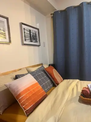 a bedroom with a bed with a blue curtain at Spacious 1Bedroom Condotel Resort in Manila