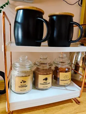 three jars of honey on a shelf with black pots at Casa Prian in Manila