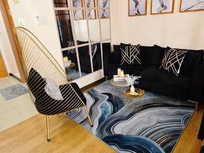 a living room with a black couch and a glass table at Casa Prian in Manila