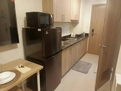 a kitchen with a black refrigerator and a microwave at Candid Suite by ARL in Manila