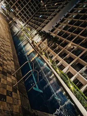 a pool of water in front of a tall building at Candid Suite by ARL in Manila