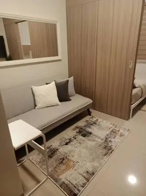 a living room with a couch and a rug at Candid Suite by ARL in Manila