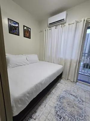 a bedroom with a white bed and a window at 1554 Apartel Breeze Resident in Manila