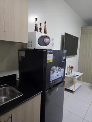 a kitchen with a microwave on top of a refrigerator at 1554 Apartel Breeze Resident in Manila
