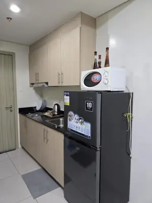 a kitchen with a black refrigerator and a microwave at 1554 Apartel Breeze Resident in Manila