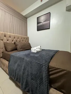 a bedroom with a bed with a television on the wall at M&M Condostay at Shore 2 Residences Tower 2 in Manila