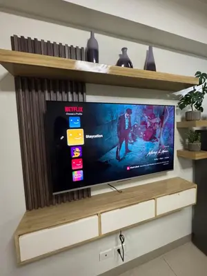 a television on a shelf in a living room at M&M Condostay at Shore 2 Residences Tower 2 in Manila
