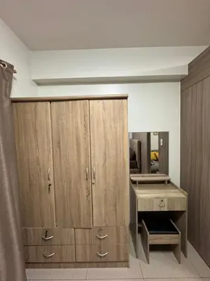 a room with a desk and a wooden cabinet at M&M Condostay at Shore 2 Residences Tower 2 in Manila