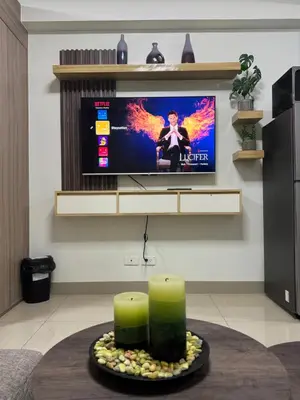 a living room with two candles and a flat screen tv at M&M Condostay at Shore 2 Residences Tower 2 in Manila