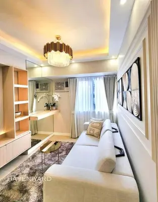 a living room with a white couch and a chandelier at Luxe 3BR unit in the heart of BGC Taguig in Manila