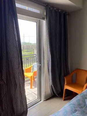 a bedroom with a sliding glass door to a balcony at Ivy Condotels unit-150 Newport Boulevard near terminal 3 and all Airport in Manila