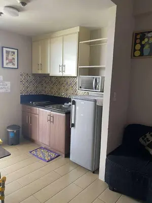a small kitchen with a white refrigerator and cabinets at Ivy Condotels unit-150 Newport Boulevard near terminal 3 and all Airport in Manila