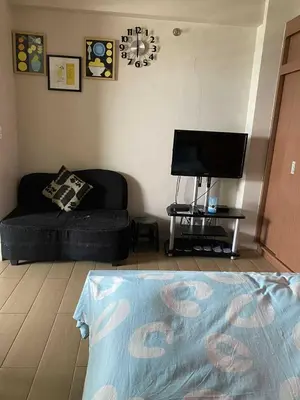 a living room with a couch and a flat screen tv at Ivy Condotels unit-150 Newport Boulevard near terminal 3 and all Airport in Manila