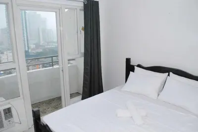 a bed with a cross on it in a room with a window at Brianna's haven property rental in Manila