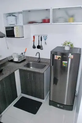 a kitchen with a sink and a stainless steel refrigerator at Brianna's haven property rental in Manila