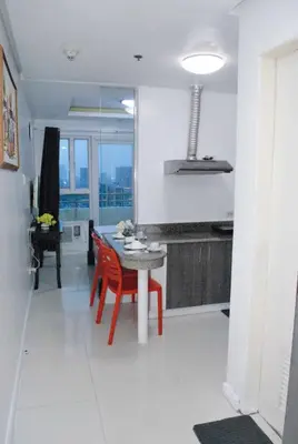 a kitchen with a table and red chairs in a room at Brianna's haven property rental in Manila