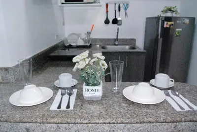 a kitchen counter with plates and a vase with flowers on it at Brianna's haven property rental in Manila