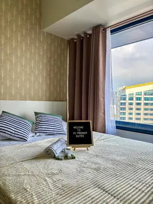 a bedroom with a bed with a sign on it at R7 Premier Suites - 1 bedroom in Air Residences in Manila