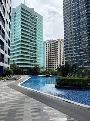 a large swimming pool in a city with tall buildings at R7 Premier Suites - 1 bedroom in Air Residences in Manila