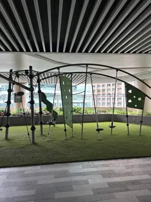 a swing set in a room with green grass at R7 Premier Suites - 1 bedroom in Air Residences in Manila