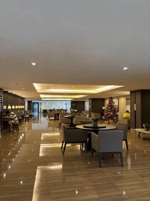 a lobby with tables and chairs and a christmas tree at R7 Premier Suites - 1 bedroom in Air Residences in Manila