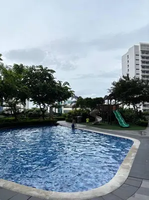 a large blue pool with a slide and a playground at R7 Premier Suites - 1 bedroom in Air Residences in Manila