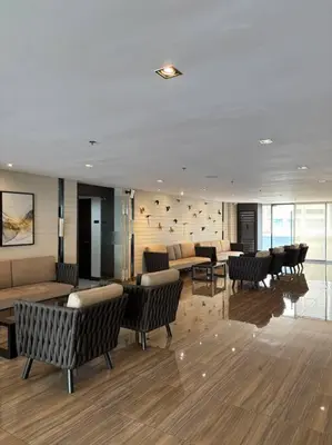 a lobby with chairs and couches in a building at R7 Premier Suites - 1 bedroom in Air Residences in Manila