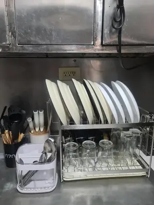 a shelf with plates and utensils in a kitchen at Js Guest House in Imus