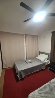a bedroom with a bed with a ceiling fan at Js Guest House in Imus