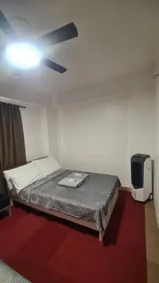 a bedroom with a bed and a ceiling fan at Js Guest House in Imus