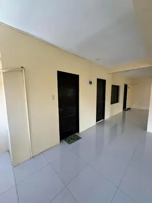 an empty room with black doors and white tile floors at Js Guest House in Imus
