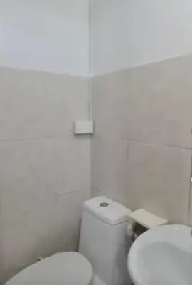 a white bathroom with a toilet and a sink at Js Guest House in Imus