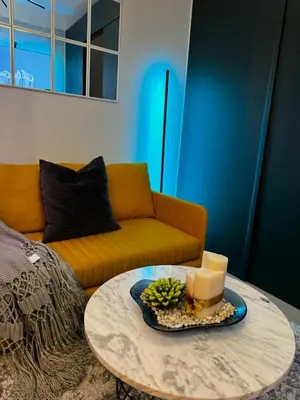 a living room with a couch and a coffee table at Evergreen suite- 1 bed 1 sofa bed, light sync TV in Manila