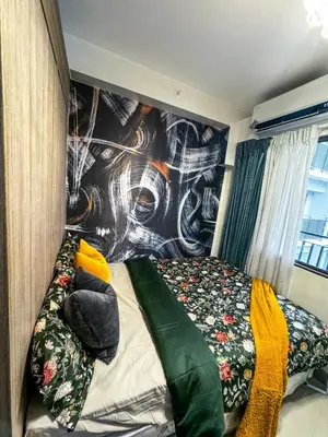 a bedroom with a bed with a painting on the wall at Evergreen suite- 1 bed 1 sofa bed, light sync TV in Manila