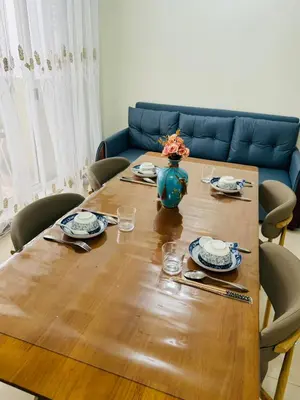 a wooden table with a vase of flowers on it at FAIRLANE residences in Manila