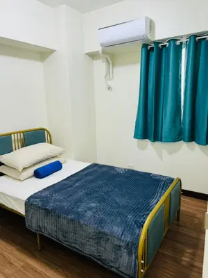 a bed in a room with blue curtains at FAIRLANE residences in Manila