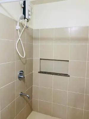 a shower with a shower head in a bathroom at Fairlane Residences in Manila