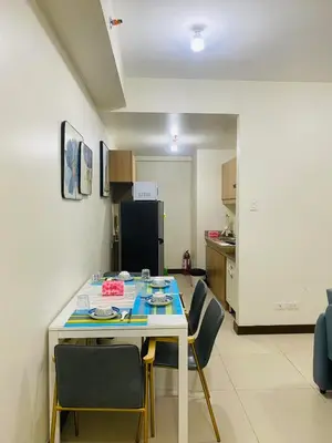 a kitchen with a table and chairs in a room at Fairlane Residences in Manila
