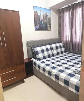 a small bedroom with a bed and a dresser at Coast Residences - 1 Bedroom with Balcony near PICC, WTC, Star City & MOA in Manila
