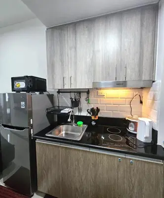 a kitchen with a sink and a stove and a refrigerator at Coast Residences - 1 Bedroom with Balcony near PICC, WTC, Star City & MOA in Manila