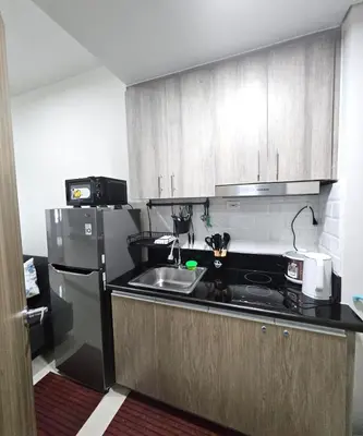 a kitchen with a sink and a refrigerator at Coast Residences - 1 Bedroom with Balcony near PICC, WTC, Star City & MOA in Manila
