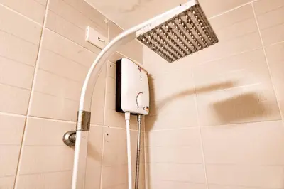 a shower with a shower head in a bathroom at Spacious Pool View 2br 2bath Apt in Makati in Manila