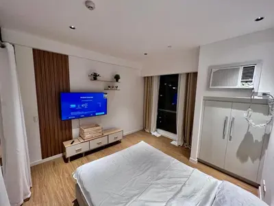 a bedroom with a bed and a flat screen tv at Novotel Residential Tower at Acqua Private Residences Mandaluyong - Makati in Manila