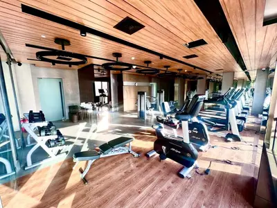 a gym with several treadmills and elliptical machines at Novotel Residential Tower at Acqua Private Residences Mandaluyong - Makati in Manila