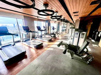 a gym with a bunch of exercise bikes and treadmills at Novotel Residential Tower at Acqua Private Residences Mandaluyong - Makati in Manila