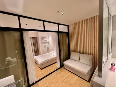 a small room with a bed and a chair and a tub at Novotel Residential Tower at Acqua Private Residences Mandaluyong - Makati in Manila